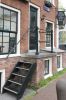 Stoep met houten trapje, pothuis en ingang aan de zijgevel (Prinsengracht 564) (© Walther Schoonenberg)